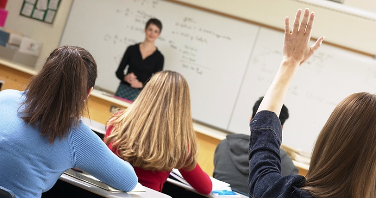 Student raising hand in classroom