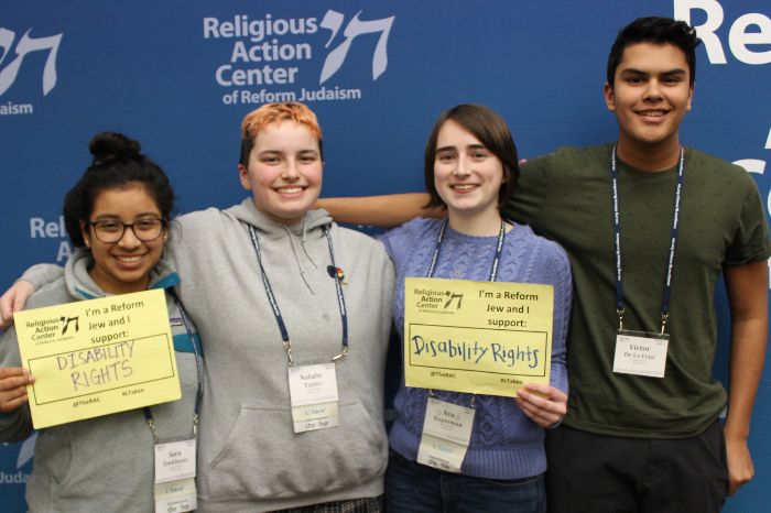 Group of teens holding signs saying I AM A REFORM JEW AND I SUPPORT DISABILITY RIGHTS